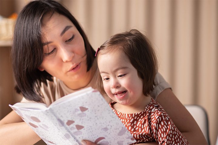 Mother and daughter with Down syndrome reading a book
